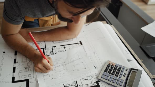 Front view video of carpenter writing and calculating. Shot with RED helium camera in 8K alt