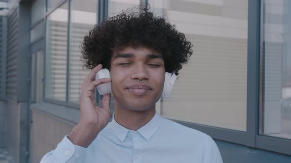 Portrait of Modern African American Attractive Smillimg Young Guy with Headphones Outdoors alt