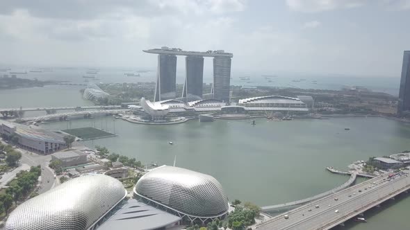 Aerial view of Singapore Marina Bay Sands mall with canal, road, cars. Modern skyscrapers in city.
