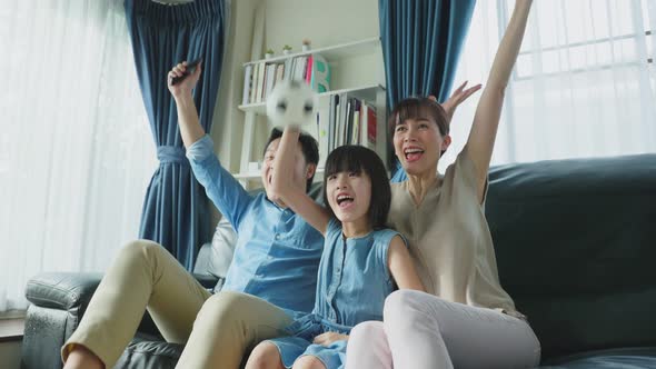 Excited Family, Young kid girl fans hold soccer ball with parents watch ...