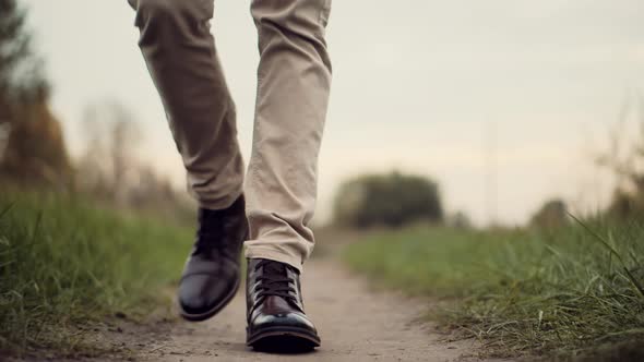 Confidence Man Feet Walking On Grass Field.Lonely Handsome Guy Rest On Holiday.Man Legs Walking Park alt