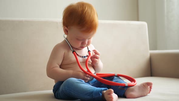 Redhead Baby Girl Puts a Stethoscope To the Herself