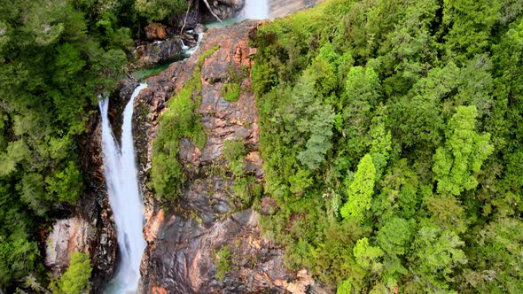 Tilt down aerial view of Rio Blanco waterfall in Hornopiren National Park, Chile alt