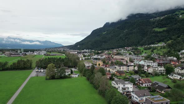 Liechtenstein with Houses on Green Fields in Alps Mountain Valley Aerial View alt