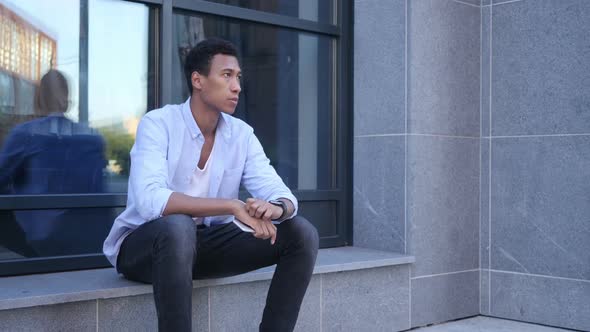 Outdoor Waiting, Watching Time, Sitting Young Black Handsome Man alt