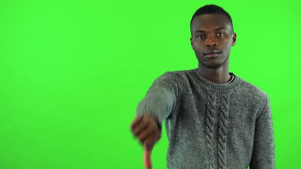 A Young Black Man Shows a Thumb Down To the Camera - Green Screen Studio alt