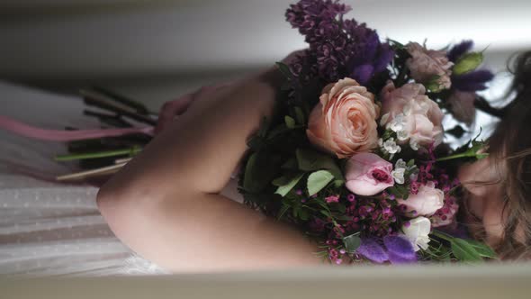 A Young Girl Hugs Flowers and Smiles alt