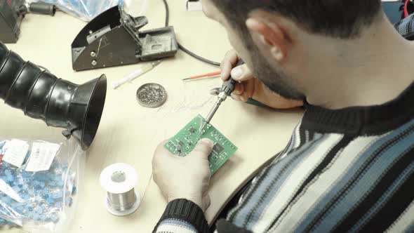 A Worker Is Working on the Creation of an Electronic Board. Close-up. alt