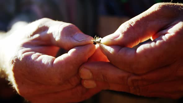 Fly fisherman preparing bait for fishing alt