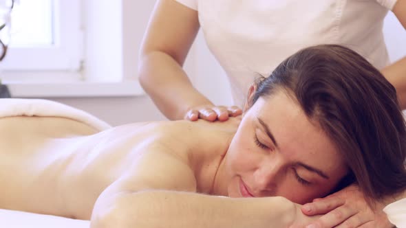 Young Pretty Woman Receives Body Massage With Aromatic Oil at Spa Salon