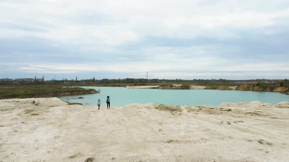 Drone Flying Low Over Travel Family at Lake Shore Journey of Mother Father Daughter alt
