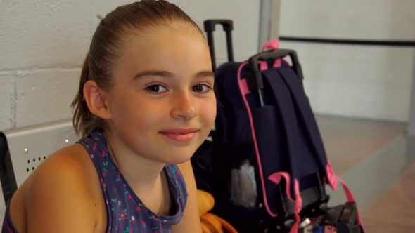 Cute Taned Girl with Big Brown Eyes Is Sitting in the Airport Lounge alt