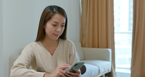 Woman use of mobile phone at home alt