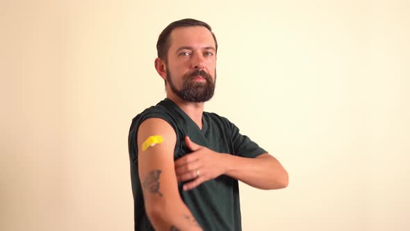 Bearded Man Showing His Arm with Bandage After Receiving Vaccine