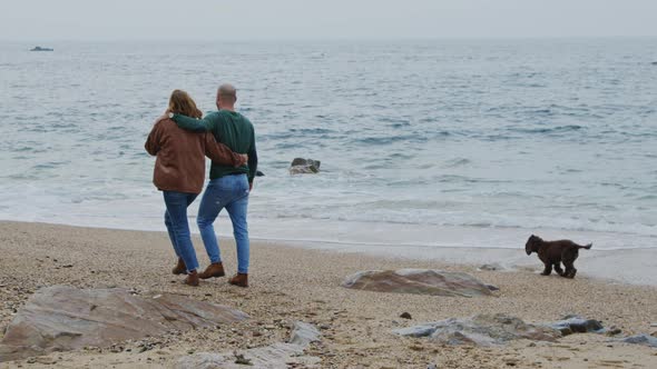 Young Couple Is Walking On Ocean Coast