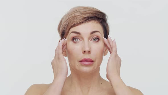 Close-up of middle aged mature woman over white background. alt