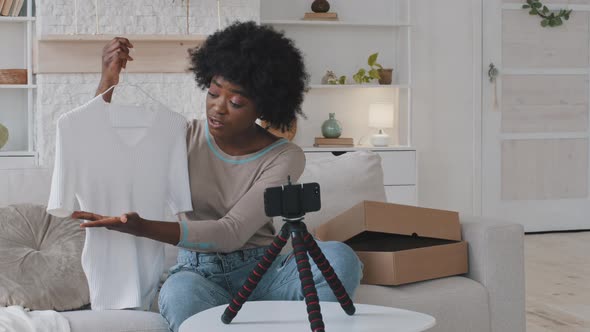 Happy Young African Beautiful Female Blogger Sitting in Front of Mobile Phone on Stabilizer alt