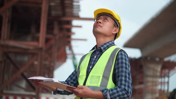Asian construction engineer checking project at the building site, Foreman worker in hardhat at the