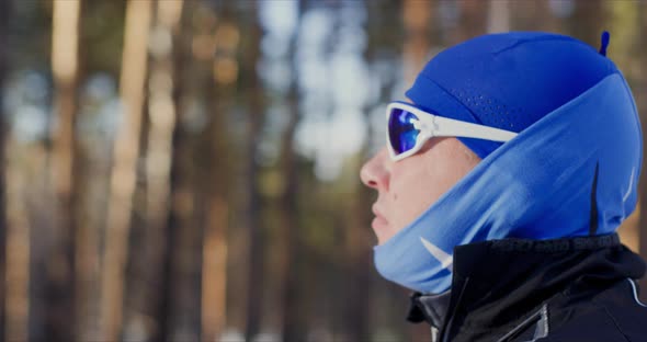 Portrait of Man in Sport Warm Clothes Hat and Blue Glasses Side View