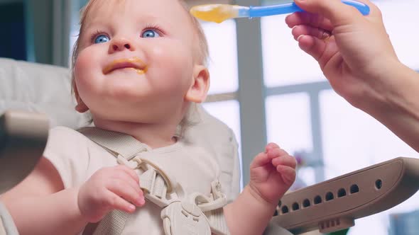 Woman Feeding Child with Spoon alt