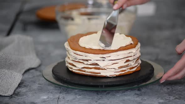 Young Caucasian Woman Making a Layer Cake with Whipping Cream
