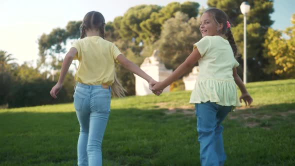 Little Girls Running in a Hedge Maze Two Sisters Kids Hold Hands and Run in Big Green Labyrinth in alt