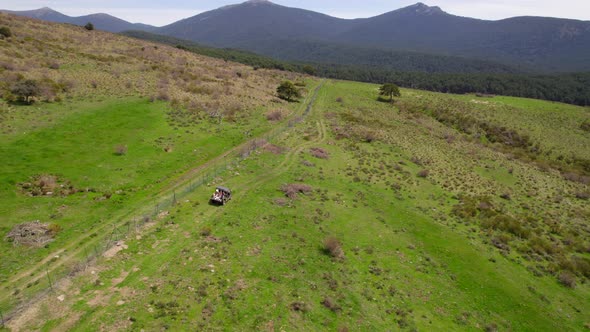 Cinematic aerial shot 4x4 car driving on green hills during sunny summer day - Adventure trip expedi alt