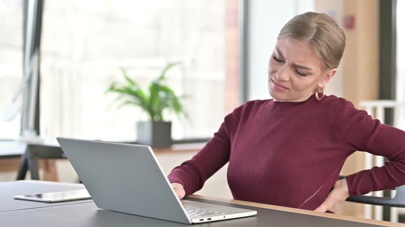 Young Woman with Back Pain Using Laptop in Office alt