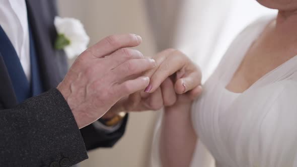Closeup Senior Male Hand Putting Wedding Ring on Female Palm in Slow Motion alt