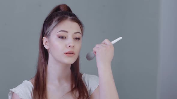 Attractive Young Woman Holding a Brush Apply Powder Foundation on the Face Healthy Skin Put