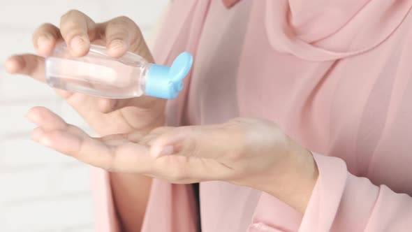 Young Women Using Hand Sanitizer with Copy Space alt