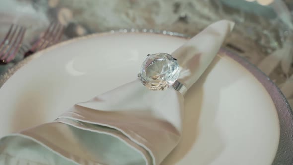 Closeup Shot of a Napkin in Beautiful Shiny Iridescent Ring Lying on a White Plate Intended for a