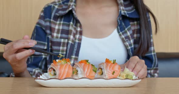 Woman eating sushi in japanese restaurant 