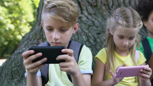 School Boy and Girl Scrolling Smartphone Looking Camera, Playing Online Game