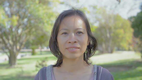 Beautiful Smiling Asian Woman Looking at Camera. alt
