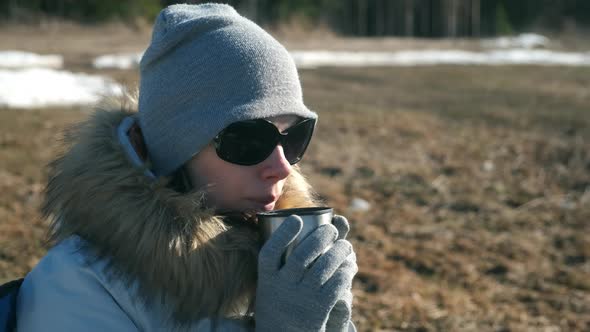 Portrait Young Woman in Hat Sun Glasses and Fur Jacket Drinking Tea on Nature