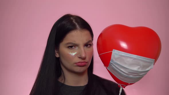 Sad Woman with Heart Ballon in Protective Mask