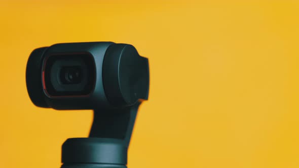 Mechanical Gimbal Camera Lens Rotates on Yellow Background Robotic Camera Macro alt