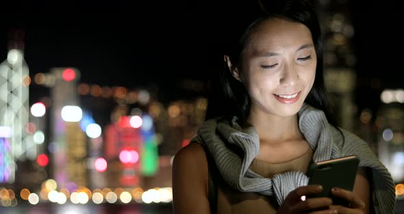 Woman using smart phone at night  alt