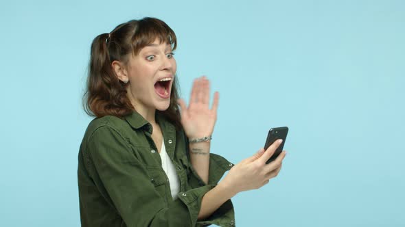 Slow Motion of Cheerful Brunette Woman with Double Ponytail Hairstyle Looking at Smartphone and
