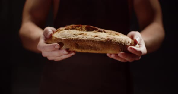 A Man Hands Out A Loaf Of Freshly Baked Bread. Home Bakery