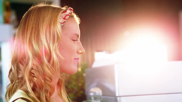 Woman paying bill through smartphone using NFC technology alt