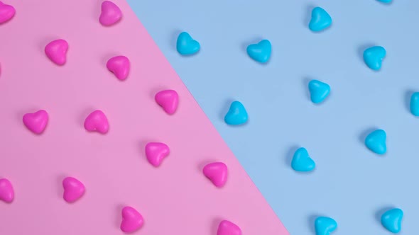 Rotating Pink and Blue Background with Heart Shaped Candies Concept of a Gende Party Trendy Sweet