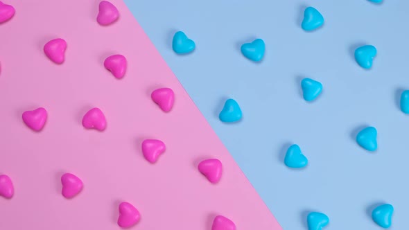 Rotating Pink and Blue Background with Heart Shaped Candies Concept of a Gende Party Trendy Sweet alt