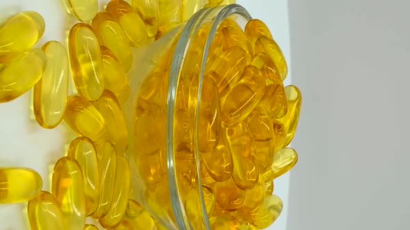 Vertical orientation video: Omega 3 (fish oil). Organic supplements vitamins yellow capsules