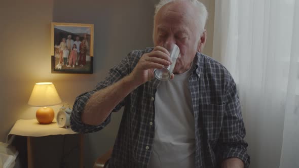 Senior Man Taking Pill in Morning alt