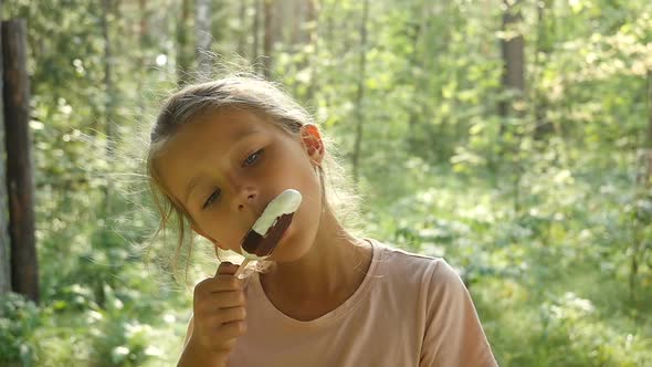 Kid Licking Ice-Cream. Charming Child Eats Ice Cream Outside. Little girl licking ice-cream.