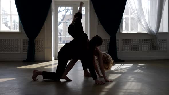 Contemporary Dancers are Rehearsing in Dance Hall Silhouettes of Young Man and Woman alt