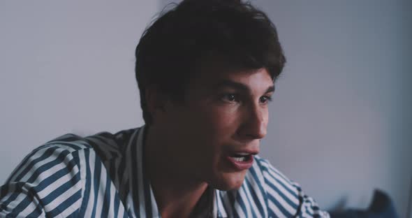 Young man receiving great news through video call alt