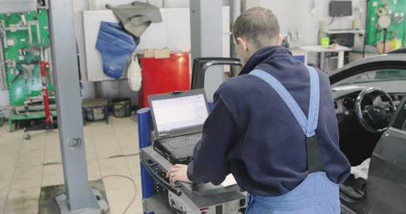 Computer Diagnostics: Mechanic Is Looking For Errors In The Car alt